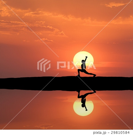 Silhouette of a standing woman practicing yoga 29810584
