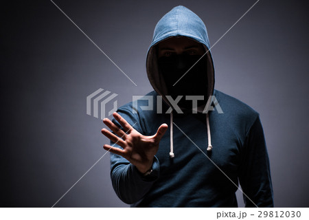 Man wearing hood in dark room Man wearing hood in dark room 29812030