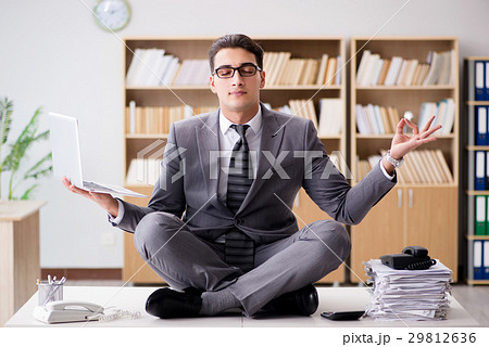 Young businessman meditating in the office Young businessman meditating in the office 29812636