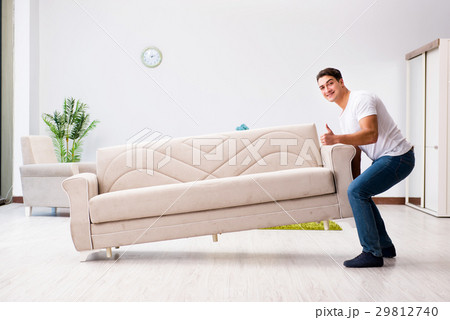 Young man moving furniture at home Young man moving furniture at home 29812740