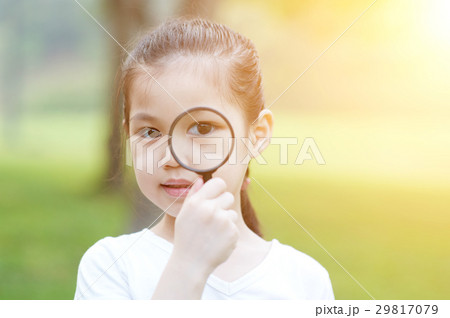Little girl with magnifier glass at outdoors. Little girl with magnifier glass at outdoors. 29817079