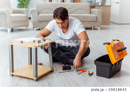 Man assembling furniture at home Man assembling furniture at home 29818645