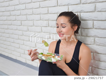 Fit healthy woman in sportswear eating a fresh Fit healthy woman in sportswear eating a fresh 29821737