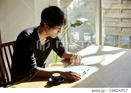 日当たりの良い部屋で読書をする男性。休日、日当たりの良いダイニングでくつろぐシーン。 29824457
