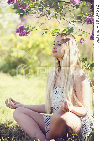 Woman meditates under a bush lilac Woman meditates under a bush lilac 29834592