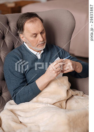 Senior man checking his temperature Senior man checking his temperature 29835867