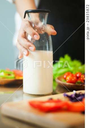 Woman hand holding milk bottle with vegetables. Woman hand holding milk bottle with vegetables. 29835872