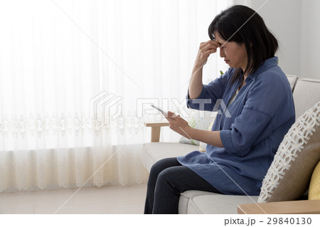 携帯電話を使う女性、眼精疲労 携帯電話を使う女性、眼精疲労 29840130