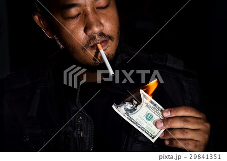 yakuza mafia using banknote lighting cigarette. 29841351