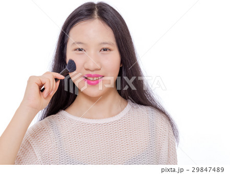 Teenage girl applying makeup with a brush 29847489