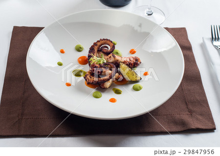 close up of cooked octopus on a white plate close up of cooked octopus on a white plate 29847956