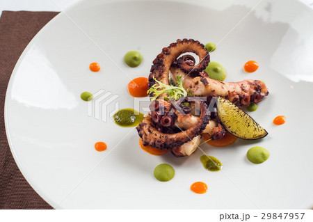 close up of cooked octopus on a white plate 29847957