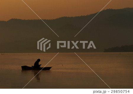 Fishing man sit and look smart phone in his boat 29850754