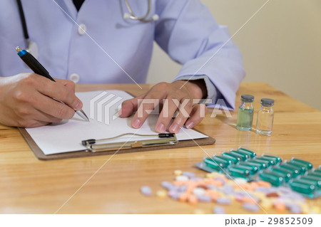 doctor writing RX prescription in medical office 29852509