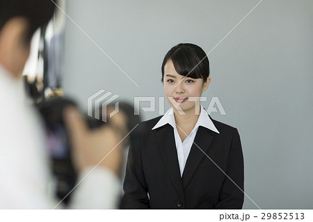 証明写真を撮影するリクルートスーツの女性の写真素材
