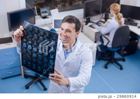 Delighted handsome doctor holding the brain Delighted handsome doctor holding the brain 29860914