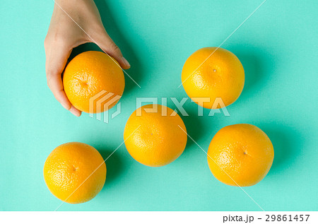 Navel oranges fruit with hand on green background Navel oranges fruit with hand on green background 29861457