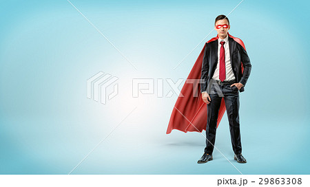 A self-assured businessman in a red cape and a 29863308