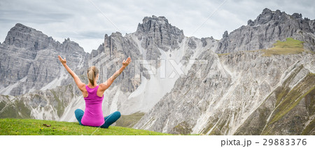 young woman meditate on top of the mountain 29883376
