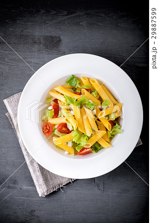 Pasta salad with fresh greenery and tomatos. 29887599