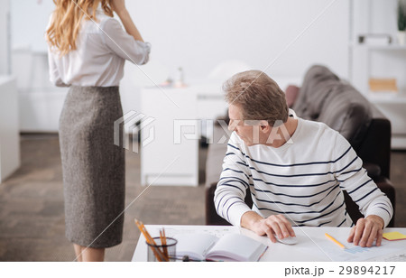 Playful aged businessman looking at young 29894217