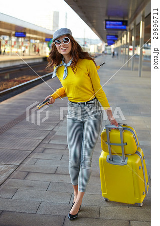 Beautiful young woman with suitcase is waiting a train Beautiful young woman with suitcase is waiting a train 29896711