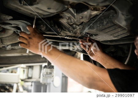 mechanic man hands at below of a car examining  29901097