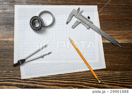 A vernier caliper holding a bearing, a pencil and 29901988