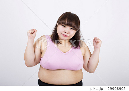 白い背景の前で両手を上げているカメラ目線の笑顔の太った若い女性 29908905