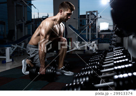 bodybuilder working out with bumbbells weights at 29913374