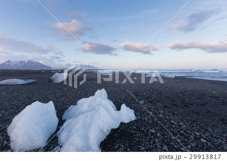 Ice on black sand beach with mountain 29913817
