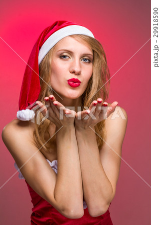 Attractive Christmas girl in santa hat on a red Attractive Christmas girl in santa hat on a red 29918590