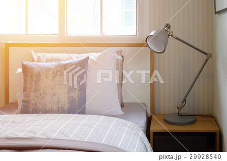 cozy bedroom with pillows and reading lamp 29928540