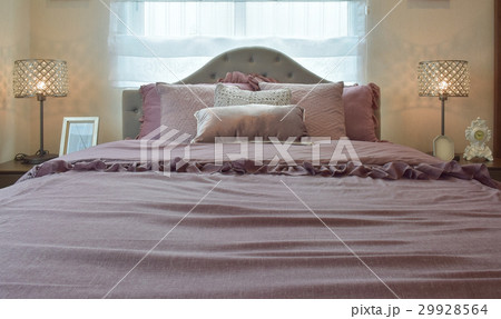 classic bedroom with pillows and reading lamp 29928564