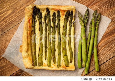 Tart with green asparagus on wooden table. 29936743