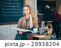 Cafe table customer young woman coffee newspaper 29938204