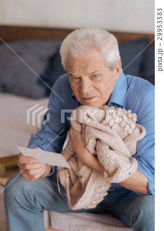 Sad depressed man pressing his wifes jacket to his 29953583