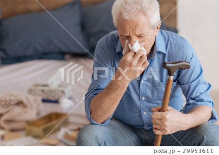 Unhappy senior man using a paper tissue 29953611