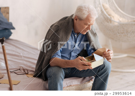Moody senior man taking a letter out of the box 29953614