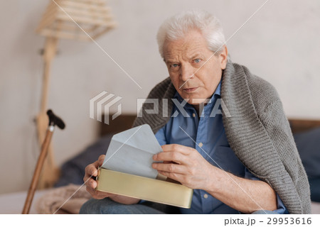 Serious thoughtful man holding the mail box 29953616