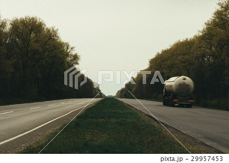 asphalt road and forest. Cars drive along the road asphalt road and forest. Cars drive along the road 29957453