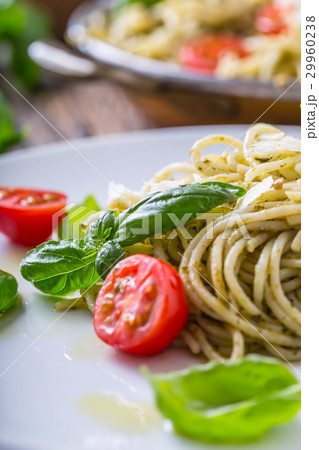 Italian spaghetti with basil pesto and tomatoes. 29960238