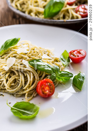 Italian spaghetti with basil pesto and tomatoes. 29960239