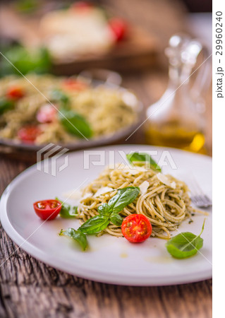Italian spaghetti with basil pesto and tomatoes. Italian spaghetti with basil pesto and tomatoes. 29960240