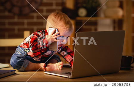 concept of baby boy working on computer and talking on phone concept of baby boy working on computer and talking on phone 29963733