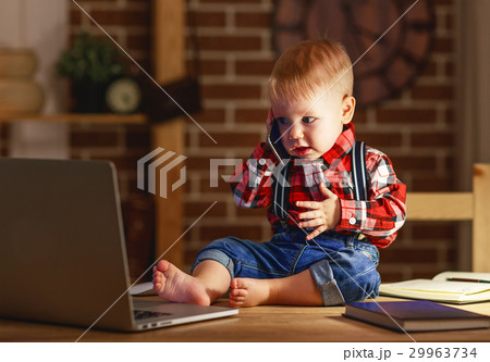 concept of baby boy working on computer and talking on phone concept of baby boy working on computer and talking on phone 29963734