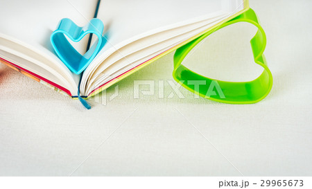 Blue and green hearts holding pages of open diary Blue and green hearts holding pages of open diary 29965673