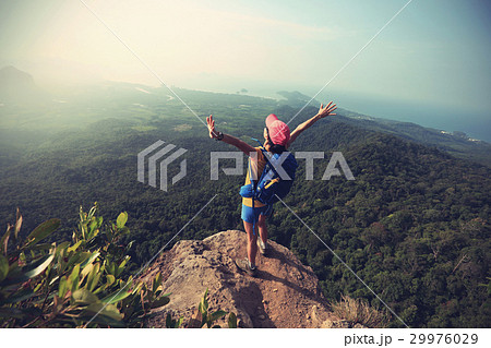 woman hiker open arms hiking on mountain peak woman hiker open arms hiking on mountain peak 29976029