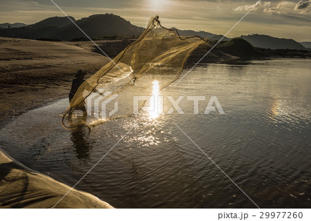 Fisherman in action when fishing in the lake Fisherman in action when fishing in the lake 29977260