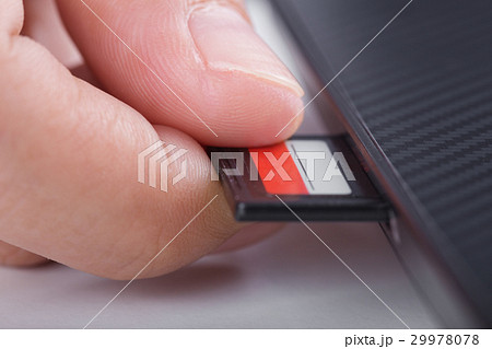 hand inserting SD card into laptop hand inserting SD card into laptop 29978078